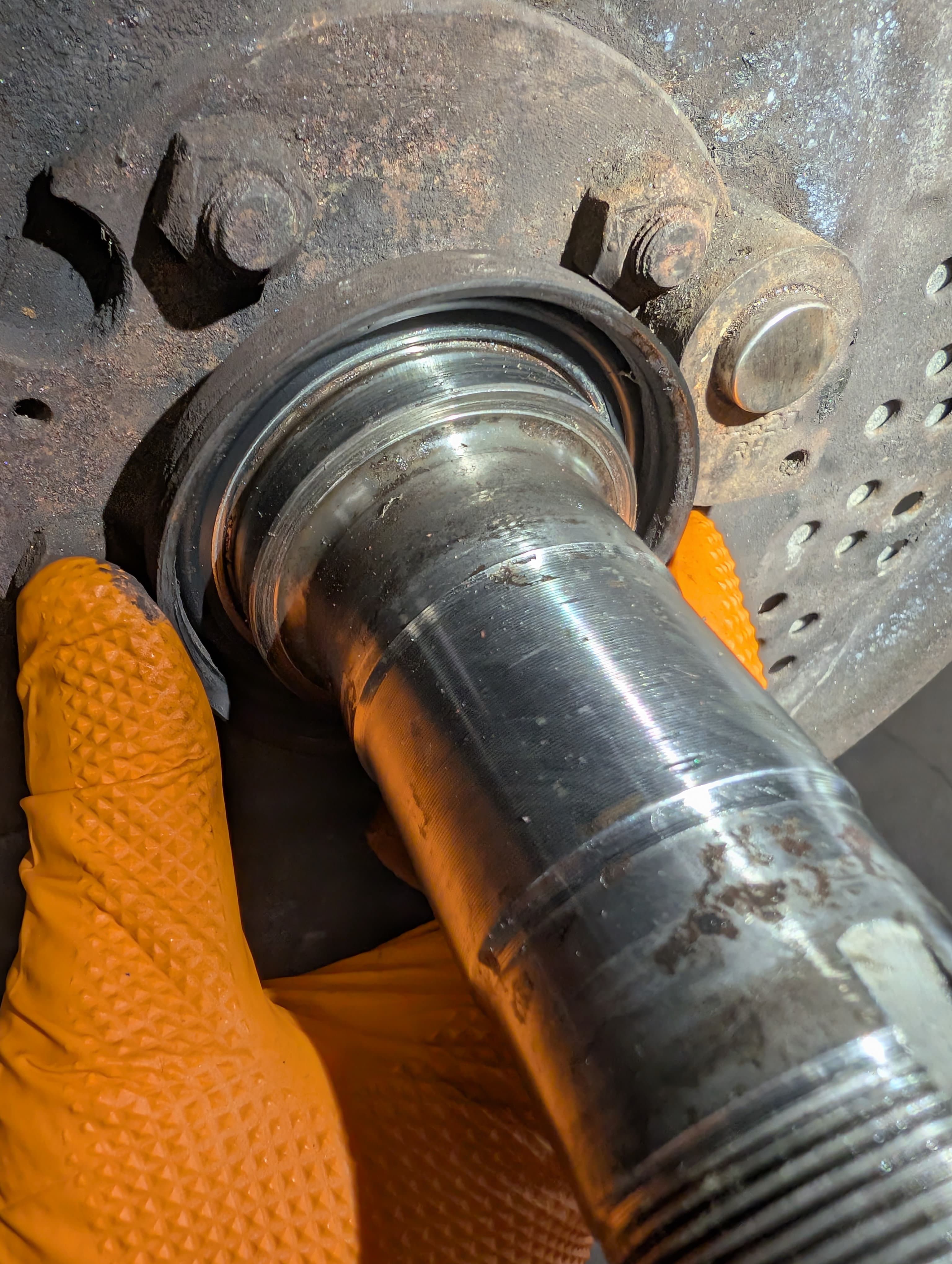Axle bearing replacement with orange safety gloves