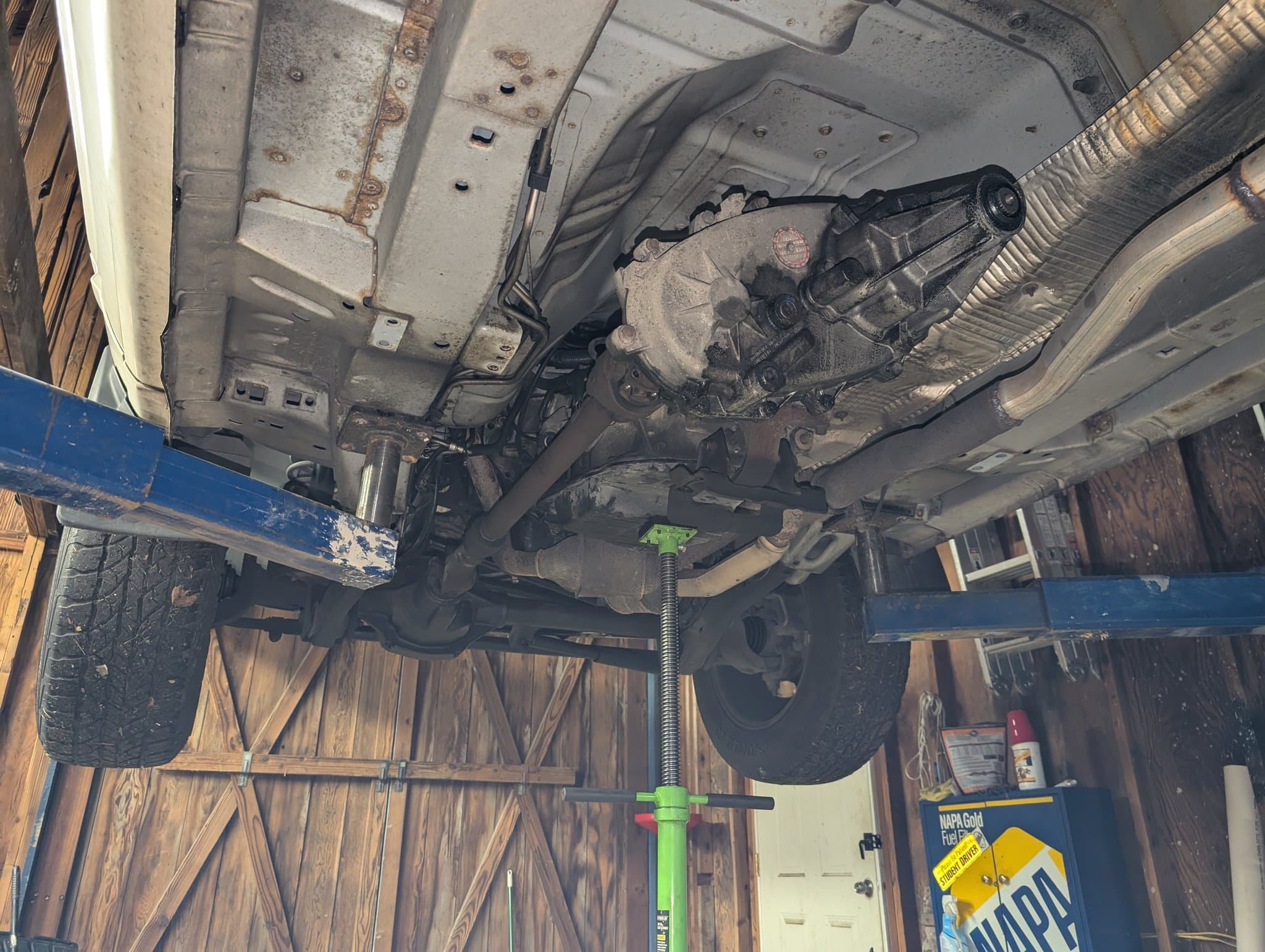 Undercarriage inspection on the lift showing drivetrain and differential