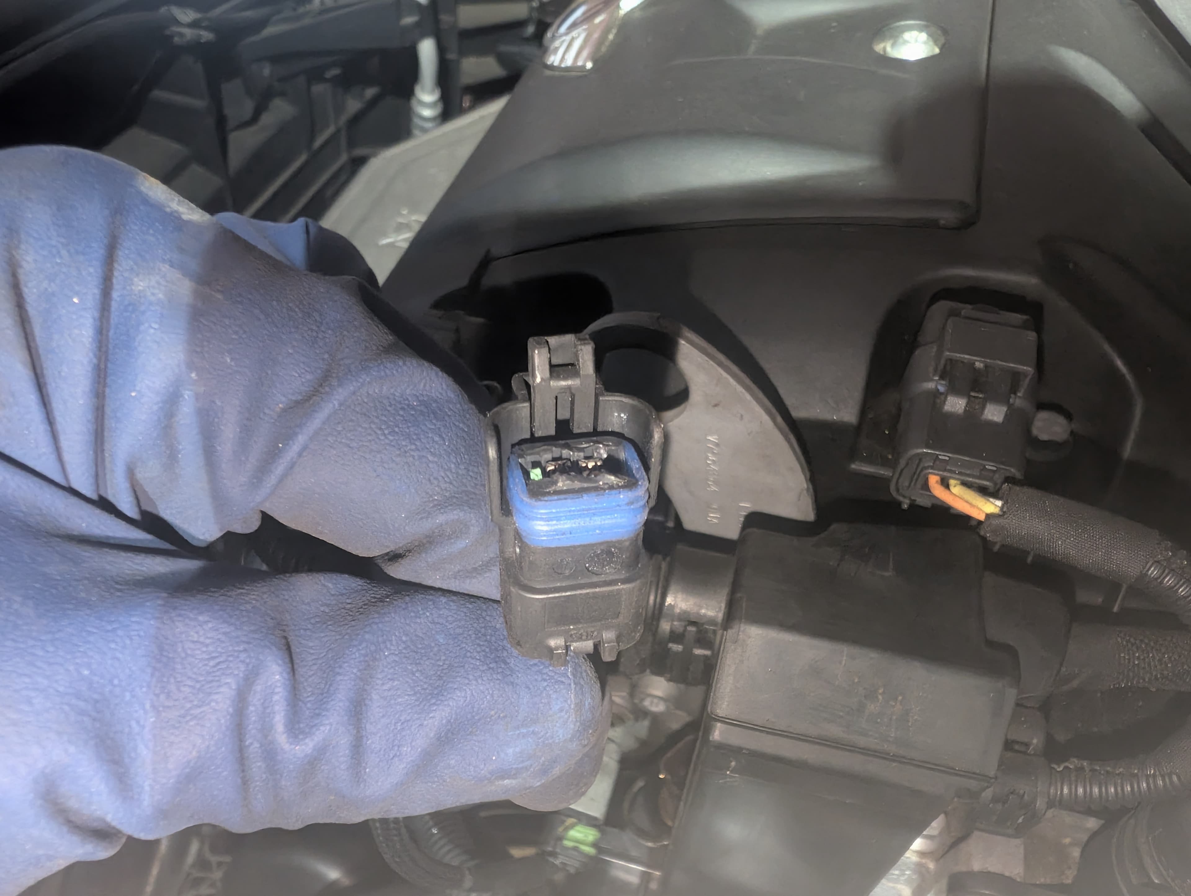 Inspecting electrical sensor connector in engine bay